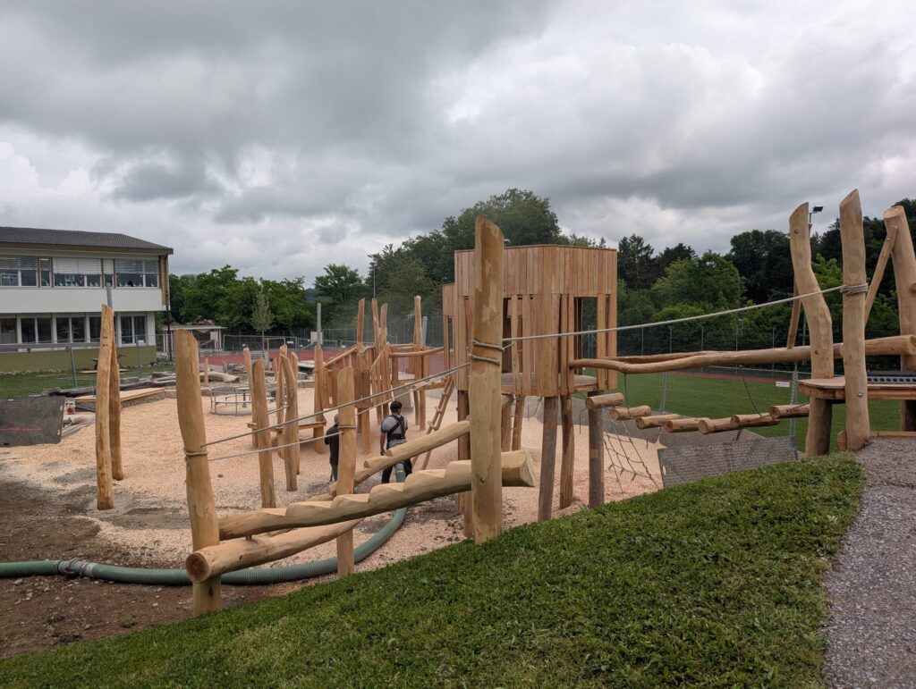 Holzspielplatz mit frischer Bodenabdeckung aus Spielplatzschnitzeln